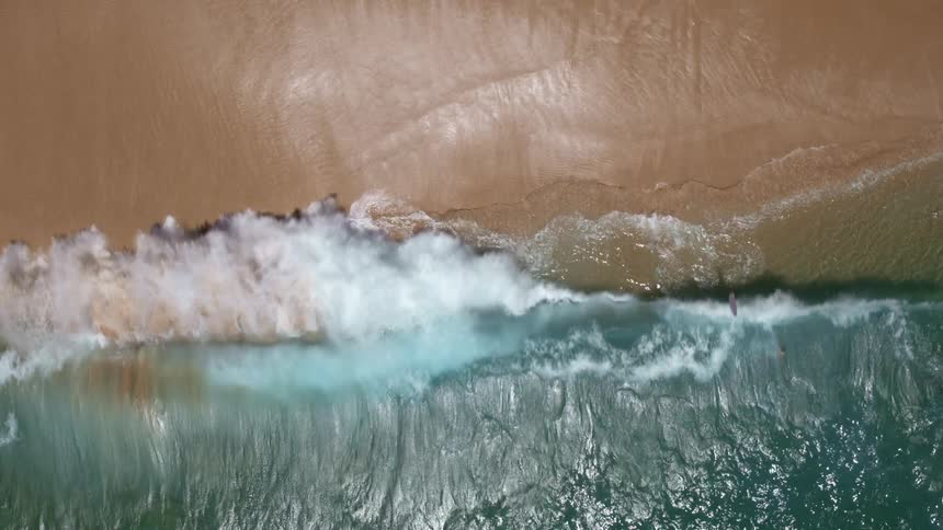 A person that is jumping into the ocean with a surfboard