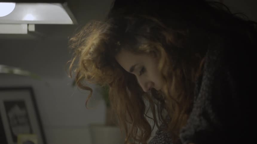 A woman is looking down examining something