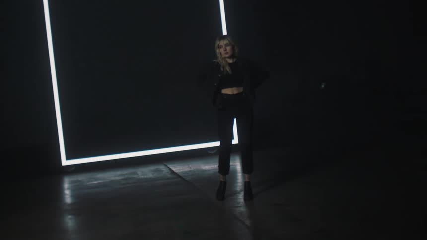 A woman walks in front of the sign