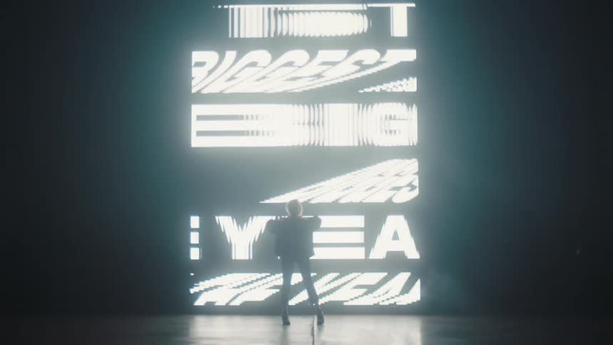 Silhouette of a woman modeling in front of a digital screen sign projected on the wall of a smoky dark room