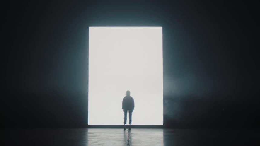A woman stands in front of a large lit up wall