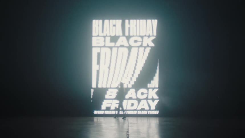Silhouette of a woman modeling in front of a black friday sign projected on the wall of a smoky dark room