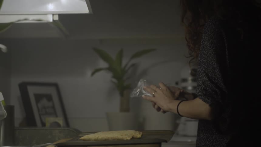 A woman is picking up things from a countertop