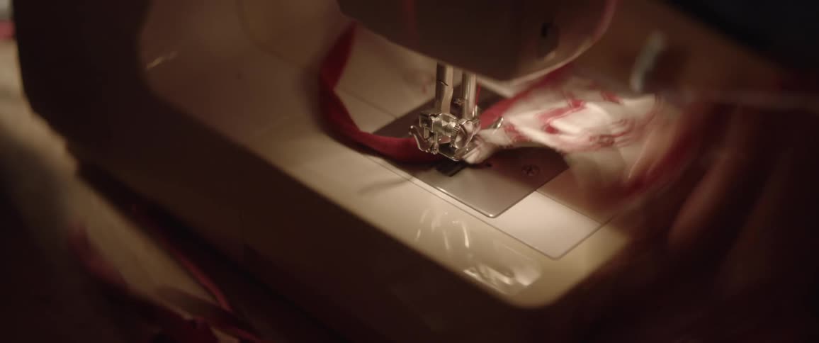 A person sewing on a sewing machine