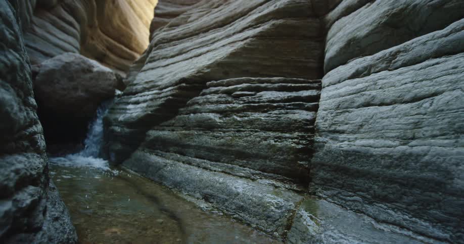 Hiker POV hiking in a slot canyon deep in Grand Canyon National Park exploring a creek in a side canyon