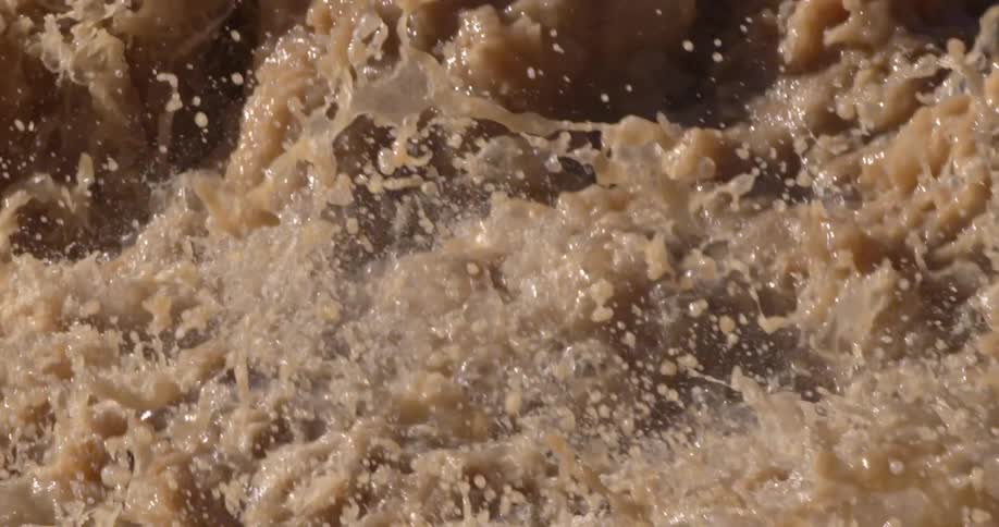 Slow motion tight shot of the Colorado River exploding and churning into droplets with the raging river in the background deep in the Grand Canyon of the Colorado River