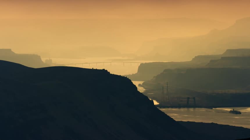 Slow pan to the right of a moody and misty Columbia River Gorge on a foggy golden light morning near Ceililo Falls