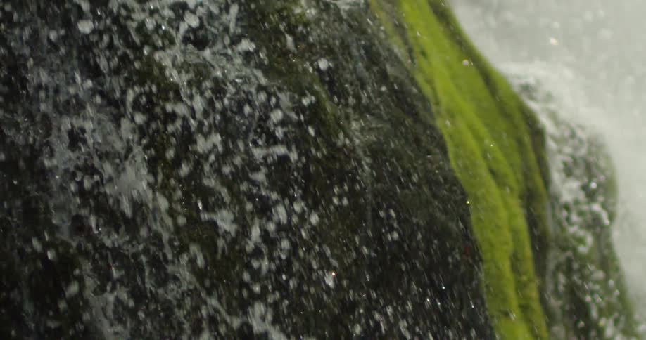 Droplets of tributary crystal clear water cascades down a mossy cliff face in this awesome slow motion shot deep in the Grand Canyon of the Colorado River