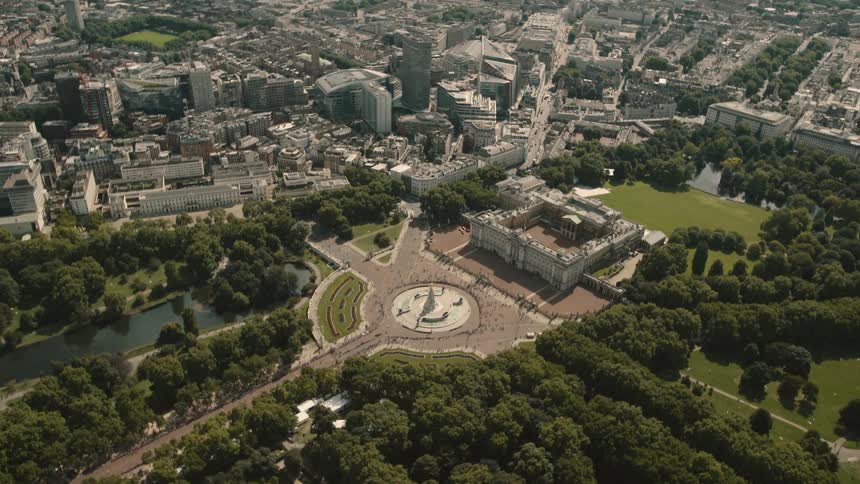 Aerial view of buckingham palace and the surrounding grounds and city with people standing in front