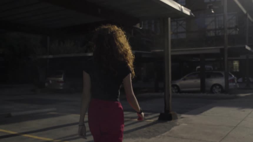 A woman walks towards a building during the day
