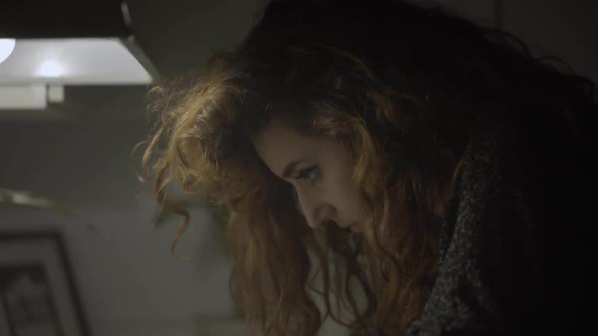 A woman is looking down then slowly opens her eyes and turns up