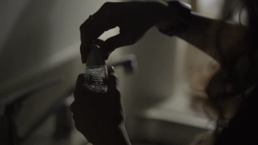 A woman screws the cap on a bottle