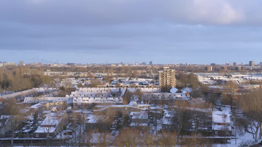 Snow covers the ground and rooftops in a neighborhood