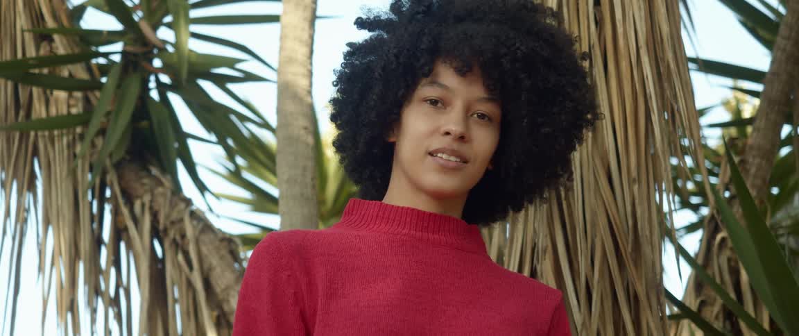 A woman is standing in a tropical area