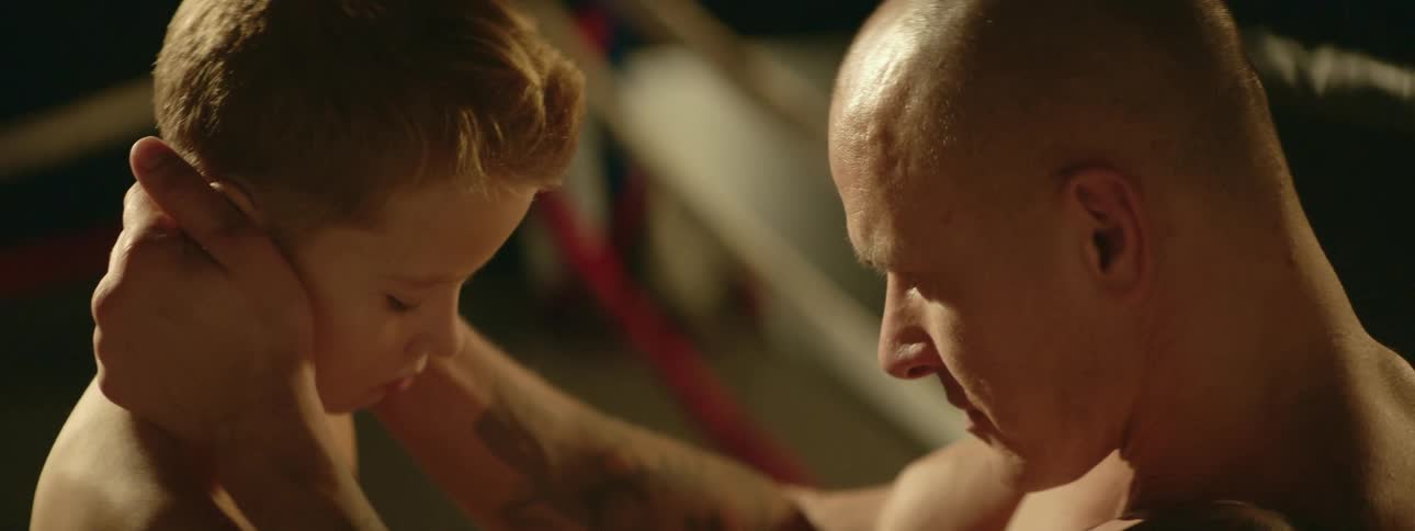A father embraces his son in boxing ring