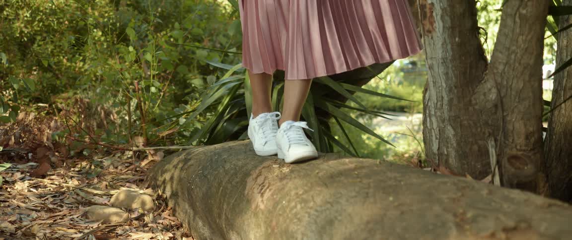 A woman walking on a log outdoors