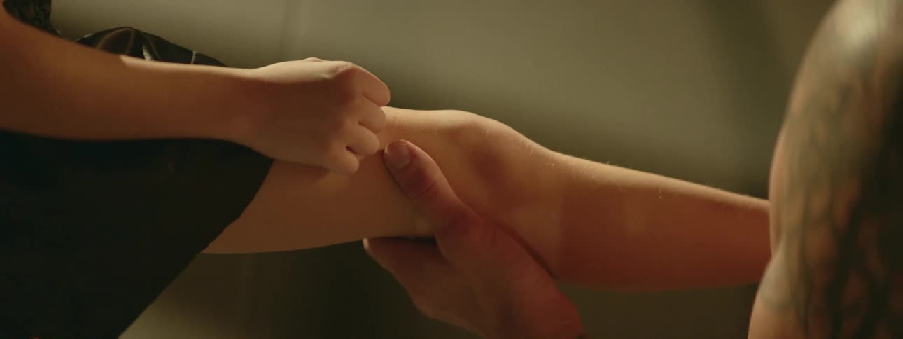 A man stretching a boys leg in a room