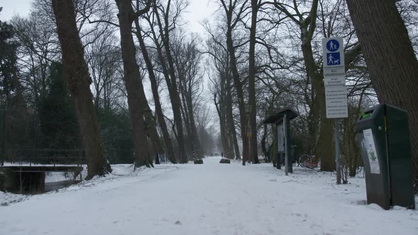 Bicycles stand near snow covered road paralleling river