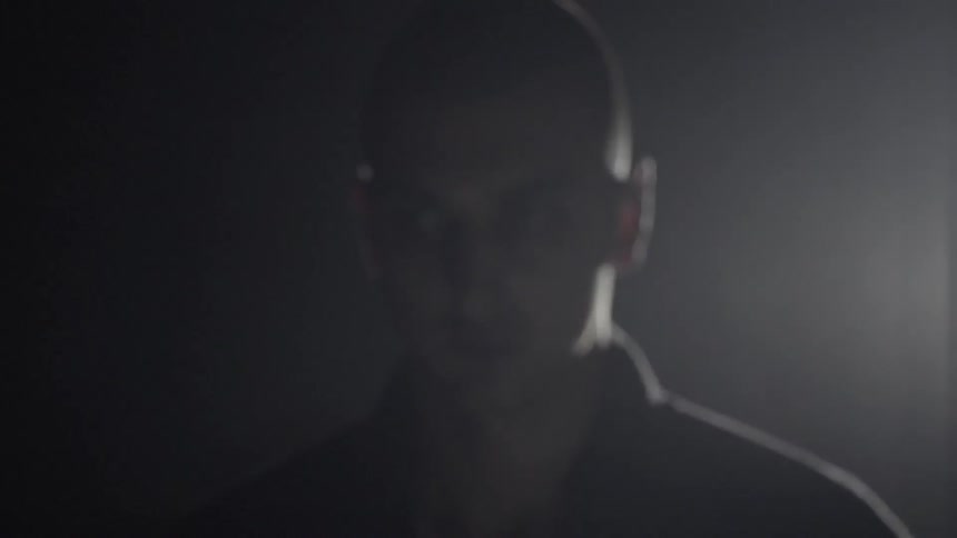 A man is staring forward in the dark
