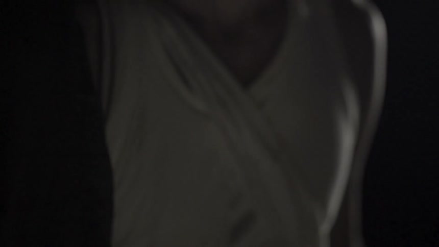 Tight shot of a person's chest comes in focus and then fades
