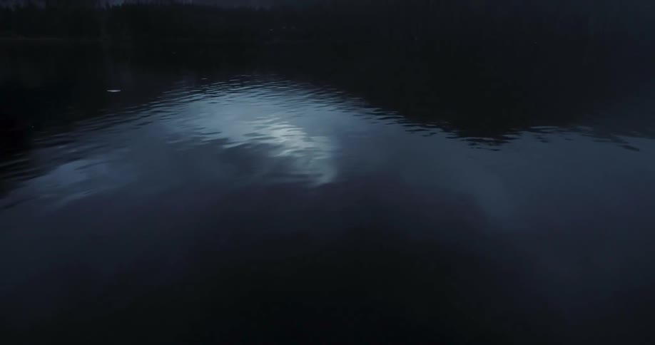 Water ripples down a river below a canyon