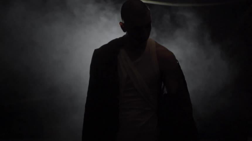 A man is standing on a dark foggy area