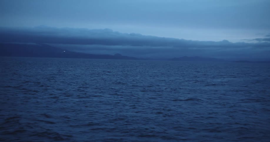 Aerial view of an ocean is displayed at dusk