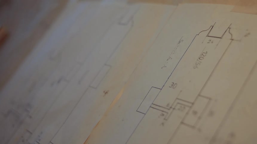 Blueprints with graphics taped on a table
