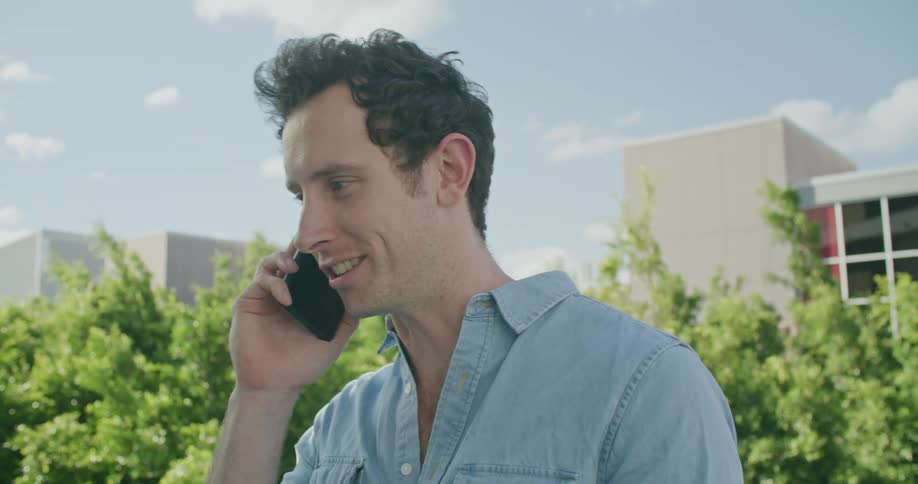 A man is talking on his cellphone outdoors in spring