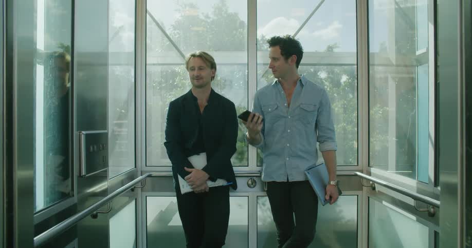 Two men are in an elevator together in a city