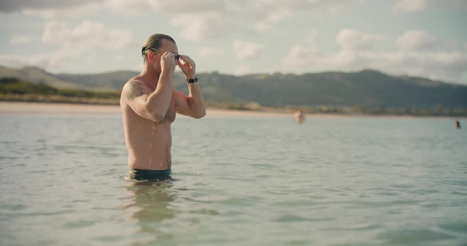 Man puts on goggles and goes for ocean swim