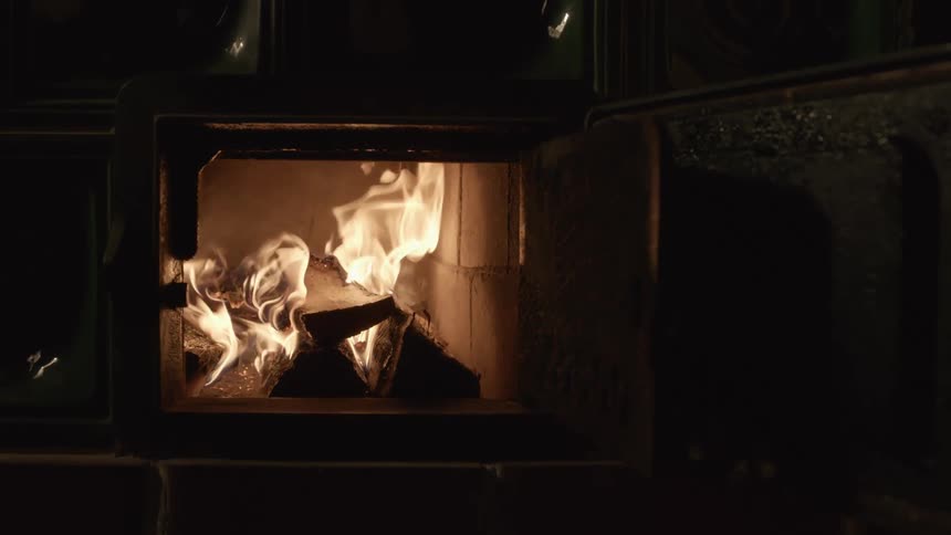 Wood burns in flames inside a furnace