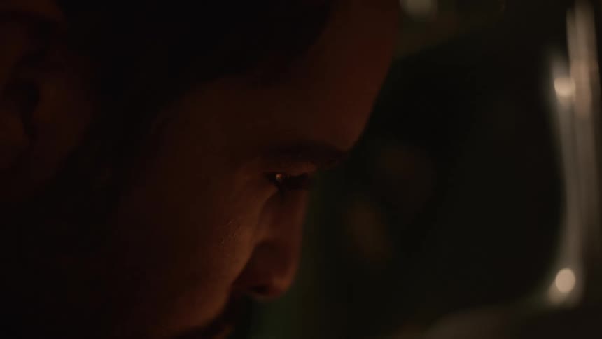 A man is warming up by a fireplace indoors