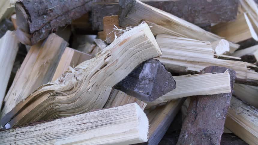 A pile of chopped wood stacked outdoors during the day