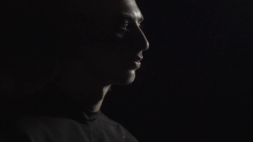 A man looks around in a dark area