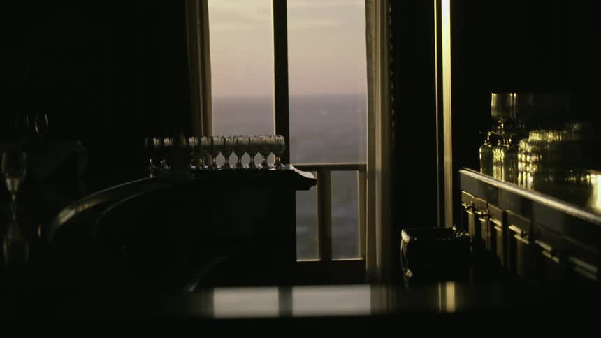 A waiter setting a tray of drinks on a bar