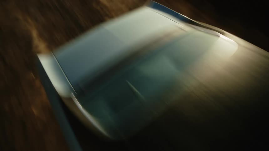 A vehicle races by the dirt road