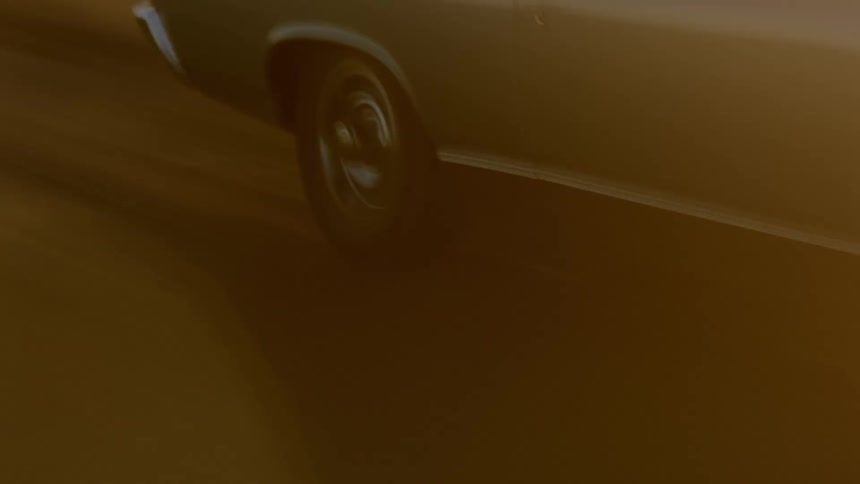 A view of a car driving down a dirt road