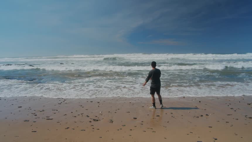 A man skipping stones into the ocean