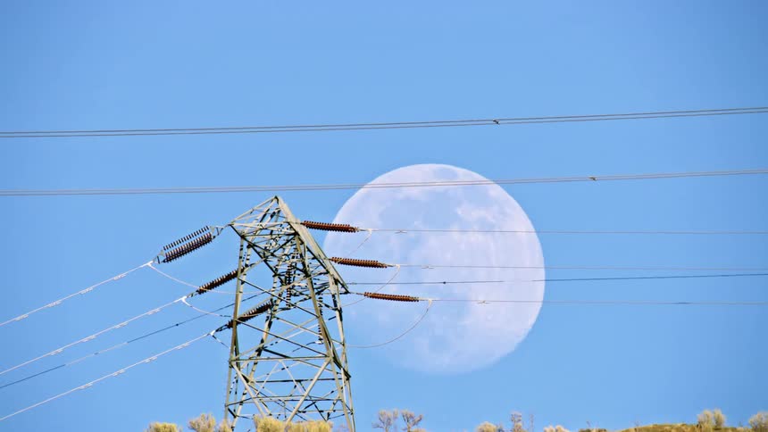 The full moon rises over electrical power and distribution lines in this stunning shot communicating the needs of now and the future in our complex world