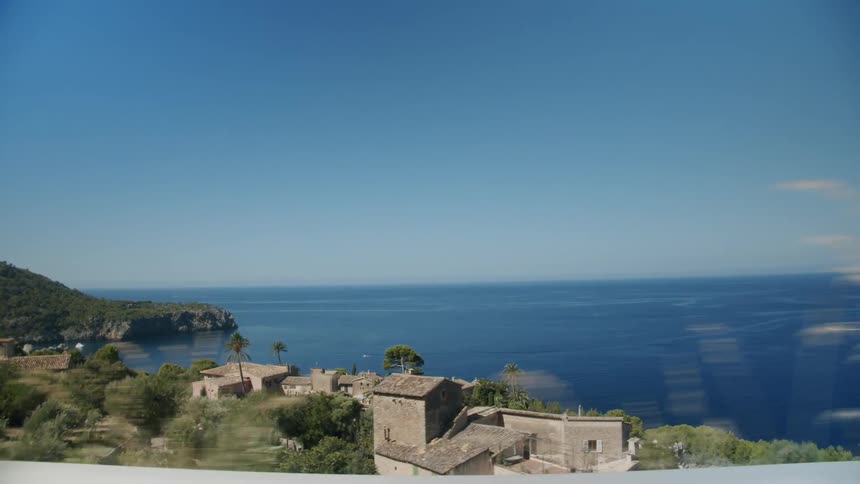 Landscape view of houses on the shore and the bright blue water with a boat in it
