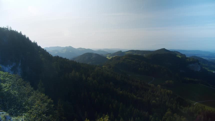 A vast mountain range covered in thick forest during the day