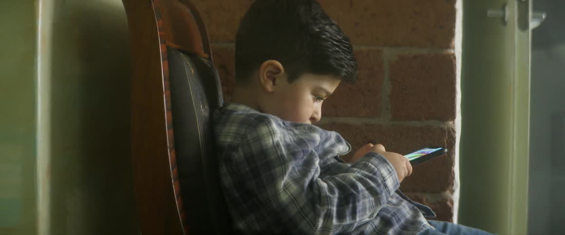 A child is playing on his phone outside
