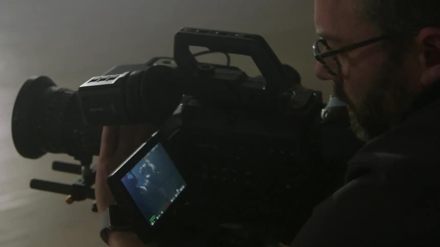 A man is checking the viewfinder of a camera