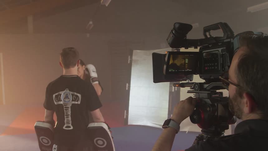A man filming people preparing to kickbox