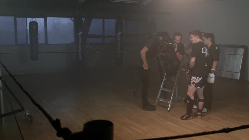 A photographer surrounded by fighters as he shows them what he's filmed