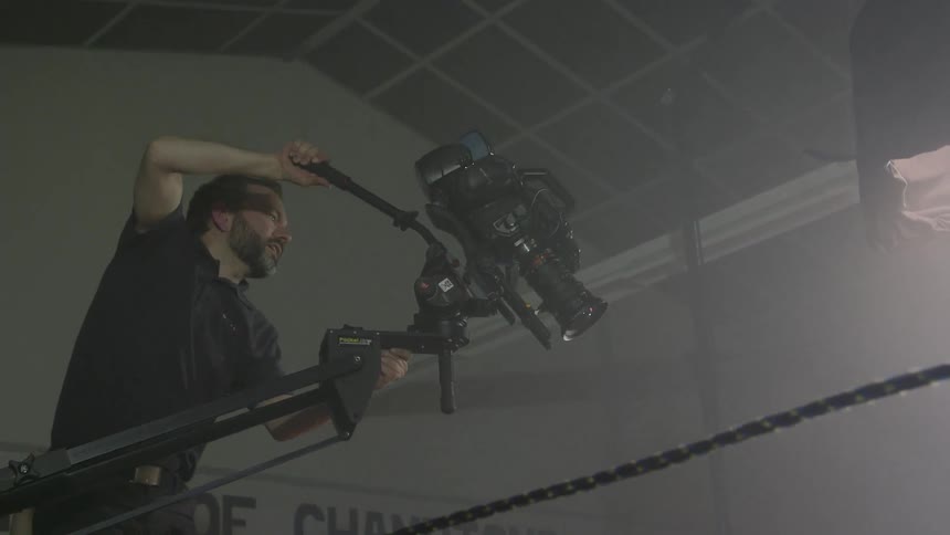 A man filming people in a boxing ring