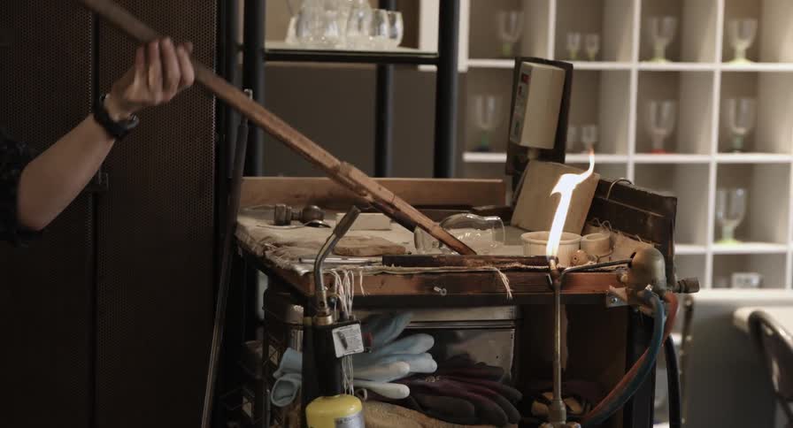 A glass artisan creating a wine glass