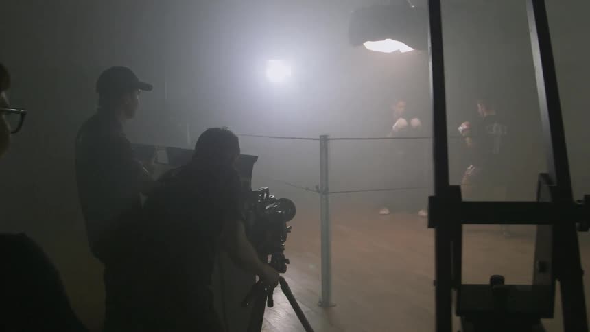 Two fighters are in a ring as they are being filmed