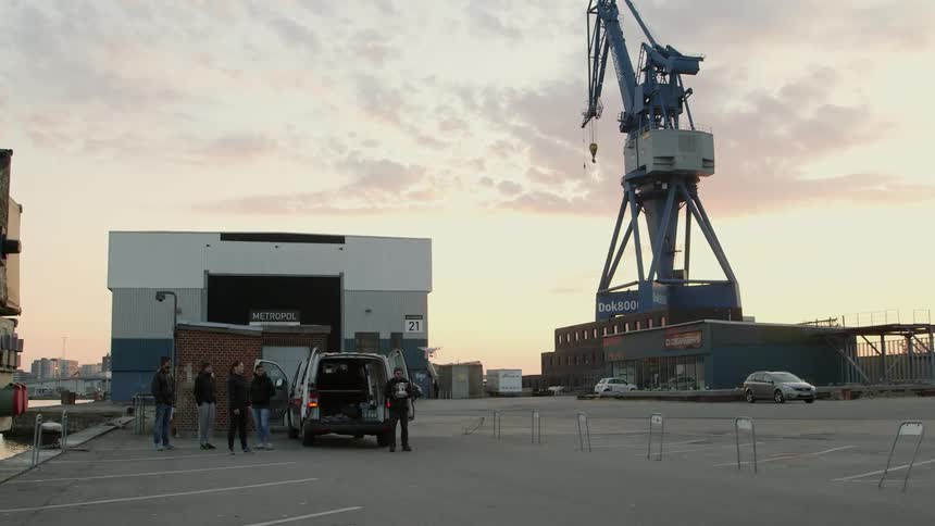 People standing near a van as a small drone takes off
